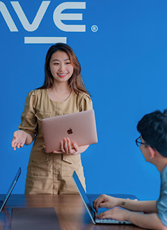 PAVE employee talking to colleagues at their computers